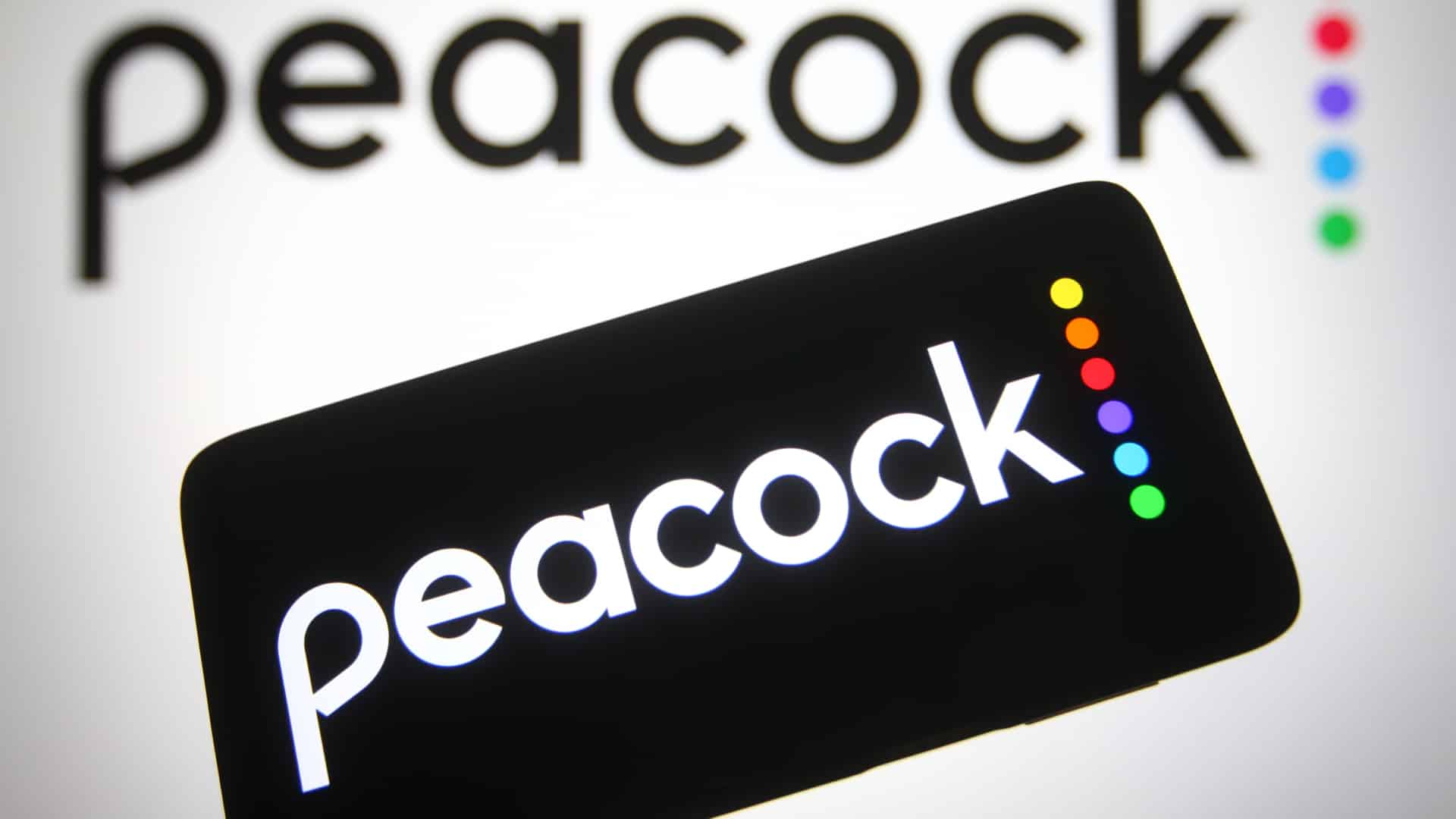 The logo of Peacock is shown in front of a computer screen.